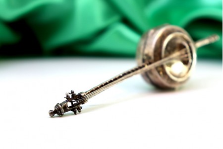 Caixa de comprimidos em prata em forma de banjo com relevos e aplicações